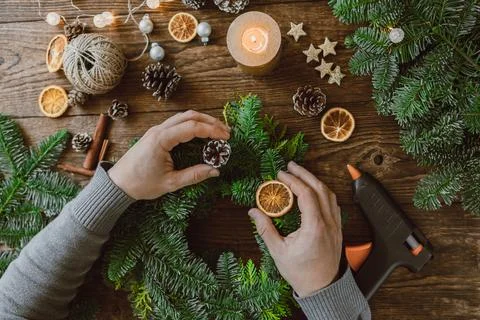 Top view of a man's hands decorating a Christmas decoration, a wreath made from Stock Photos