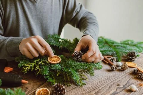 Top view of a man's hands decorating a Christmas decoration, a wreath made from Stock Photos
