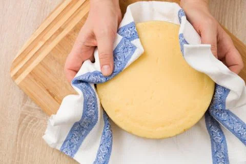 Top view on man's hands holding a head of fresh organic cheese. Food concept Stock Photos