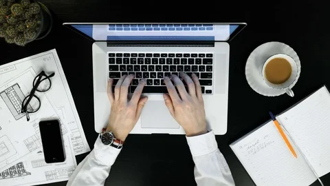 Top view of man's hands making notes in paper notebook by pen in wooden table. Stock Footage 74463989