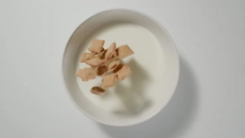 TOP VIEW: Many Cereal bites fall in a milk, slow motion Stock Footage 149543411