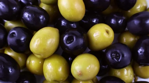 Top view of many green and black marinated whole olives circle rotation close up Stock Footage 233997299