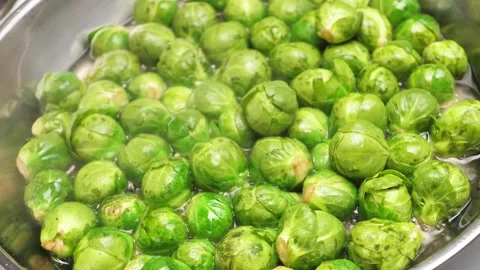 Top view of many green brussel sprouts boiling in hot vegetable oil inside a fry Stock Footage 301920420