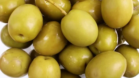 Top view of many green marinated whole olives circle rotation close up Stock Footage 233443756