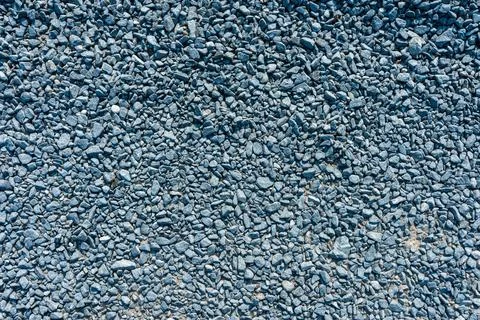 Top view of many small gray granite stones covering the ground texture Stock Photos