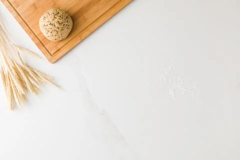 Top view of a marble table with a bread resting in a wooden board, wheat and  Stock Photos