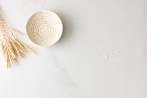Top view of a marble table with an empty bread bowl, wheat and flour with spa Stock Photos