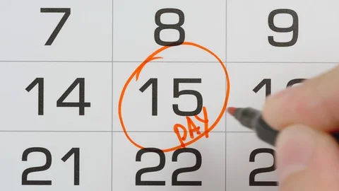 TOP VIEW: Marking a pay day in a paper calendar by red pen - Close Up shot Stock Footage 127893346