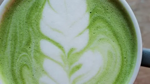 Top view of matcha green tea latte with leaf pattern art in white ceramic m.. Stock Footage 339641080