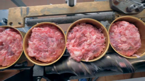 Top view of meat in tin cans going along the conveyor belt and getting closed Video stock 86377040