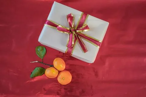 Top View Medium Shot of Beige Gift Box with Tangerines on Red Background Stock Photos