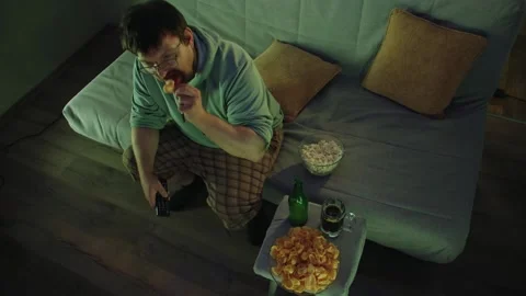 Top view of middle aged man changing channel with remote control Stock Footage 314396641