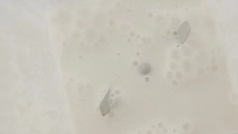 Top view milk and flour are whipped in blender for baking. Slow motion video Stock Footage 117588956