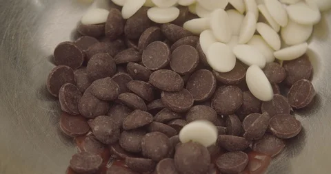 Top view milk and white chocolate melt in bowl. Slow motion video 4K Stock Footage 115500088