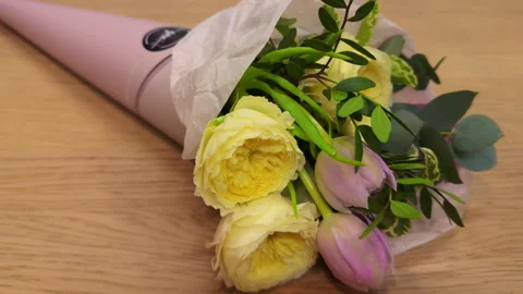 Top view of mini bouquets of fresh flowers in colorful packaging on a bright sum Stock Footage 307060788