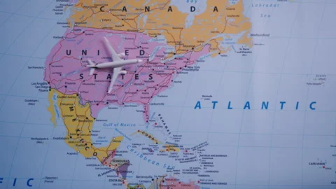 Top view of a miniature plane crossing the U.S. and the ocean on a world map Stock Footage 298588965
