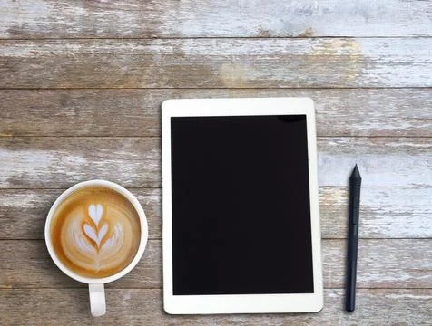 Top view Minmal workspace with tablet, headphones and coffee cup on wood tabl Foto stock
