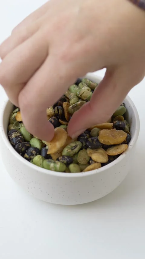 Top view of mixed green, yellow and black bean snack in white bowl as high-fiber Video stock 331010247