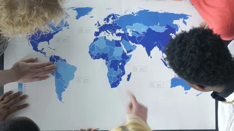 Top view of mixed-race group examining the world map Video stock 73849204