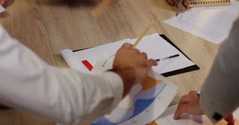 Top view of mixed-races hands working and dealing with paper documents, charts Stock Footage 82408388