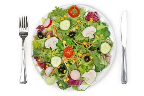 Top view of a mixed salad plate, fork and knife Stock Photos