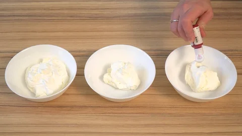 Top view of mixing the cream for decorating and dye in the bowl. Cooking Stock Footage 86766714