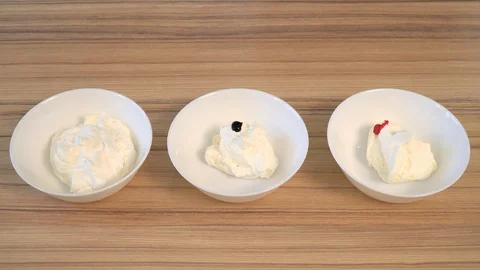 Top view of mixing the cream for decorating and dye in the bowl. Cooking Stock Footage 86767048