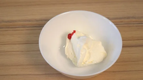 Top view of mixing the cream for decorating and dye in the bowl. Cooking Stock Footage 86767405