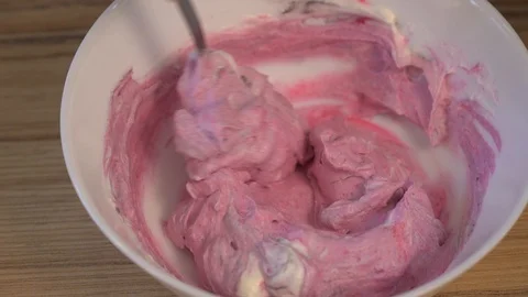 Top view of mixing the cream for decorating and dye in the bowl. Cooking Video stock 88085137