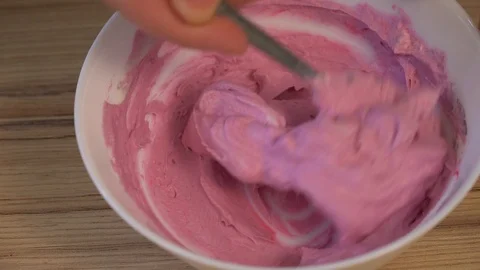 Top view of mixing the cream for decorating and dye in the bowl. Cooking Video stock 88086153