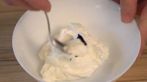 Top view of mixing the cream for decorating and dye in the bowl. Cooking Video stock 88086872