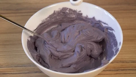Top view of mixing the cream for decorating and dye in the bowl. Cooking Video stock 88087195