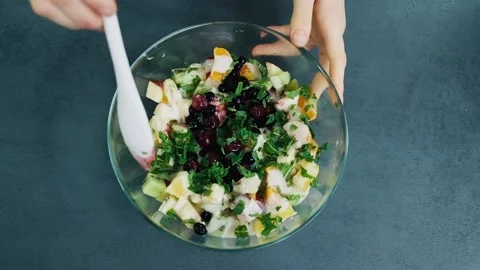 Top view of mixing fresh fruit salad with apples, oranges, kiwi, tangerines Video stock 136822941