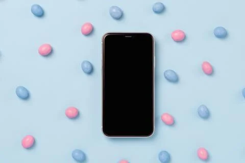Top view of mobile phone with black screen and easter dragee Stock Photos