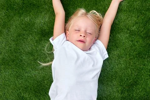 Top view. Mock up for logo, text, design. Blonde child girl closed eyes lying Stock Photos