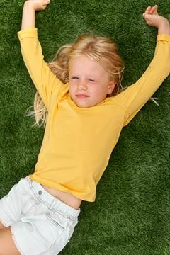Top view. Mock up for logo, text, design. Blonde long hair child girl lying,  库存照片