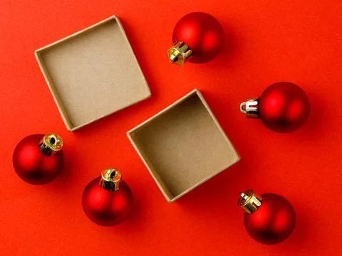 Top view mock up open present box with red christmas balls on red background Stock Photos