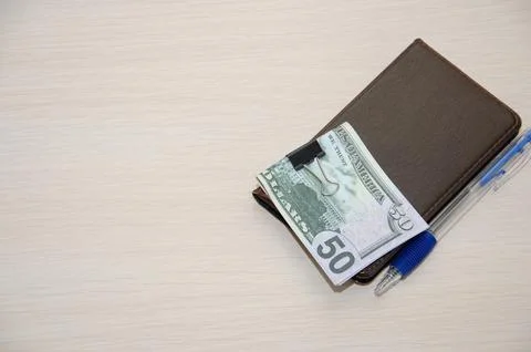 Top view mockup of open blank notebook on spiral, automatic pen and 50 dollar Stock Photos