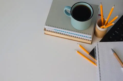 Top view on modern creative student workspace. Blue cup of coffee, notebooks Stock Photos