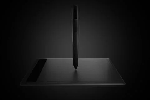 Top view of a modern graphics tablet isolated on a black background, pen for Stock Photos
