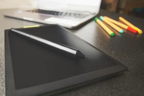 Top view of a modern graphics tablet isolated on a black background, pen for Stock Photos