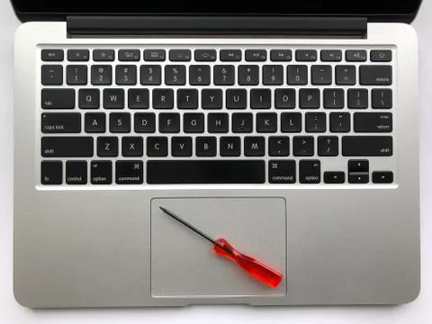 Top view of modern laptop computer with screwdriver on touchpad. Fotos Stock