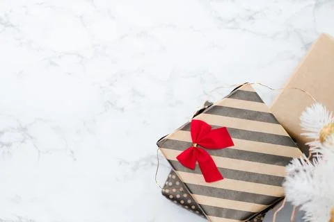 Top view of modern striped present box with red bow lay under white christm.. Stock Photos