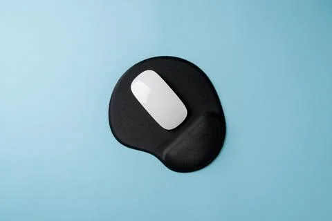 Top view of modern white mouse on black mousepad on blue table Stock Photos