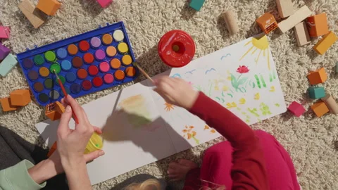 Top view of moms and daughters hands painting together on a carpet, in process Stock Footage 234399148