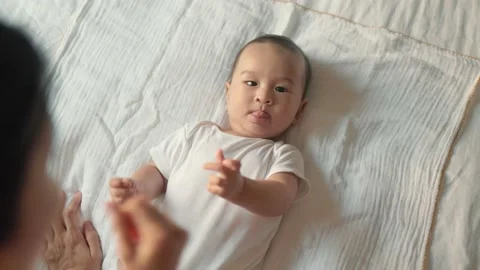 Top view of Mother stroking her baby. baby lying on bed Stock Footage 204072280