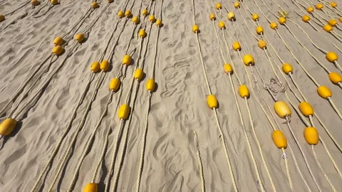 Top View motion above Yellow Oval Buoys on braided rope neatly laid out in Видео 339638877