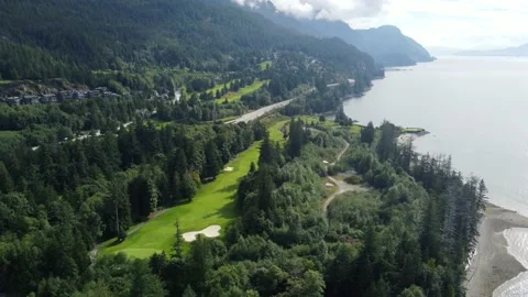 Top view of the mountains covered with forests and a bright green golf course Vídeos de archivo 164883330