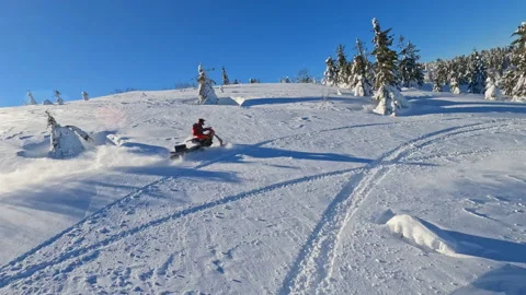 Top view in mountains, two guys on snowmobiles jump and ride in the winter at Stock Footage 195272142