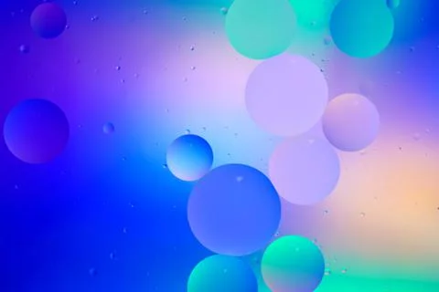 Top view movement of bubbles in the liquid. Oil surface multicolored backgrou Stock Photos